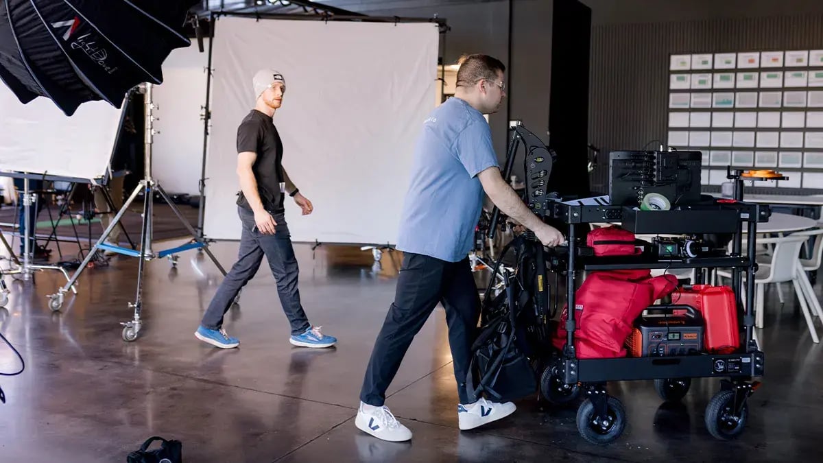 two filmmakers from Charter & Co move camera gear during a professional video production