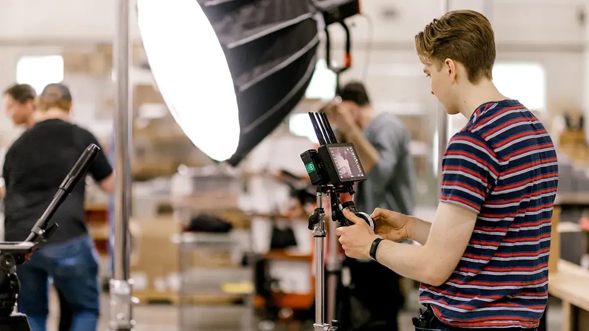 a video professional uses camera equipment during a promotional video production for Truly Engaging