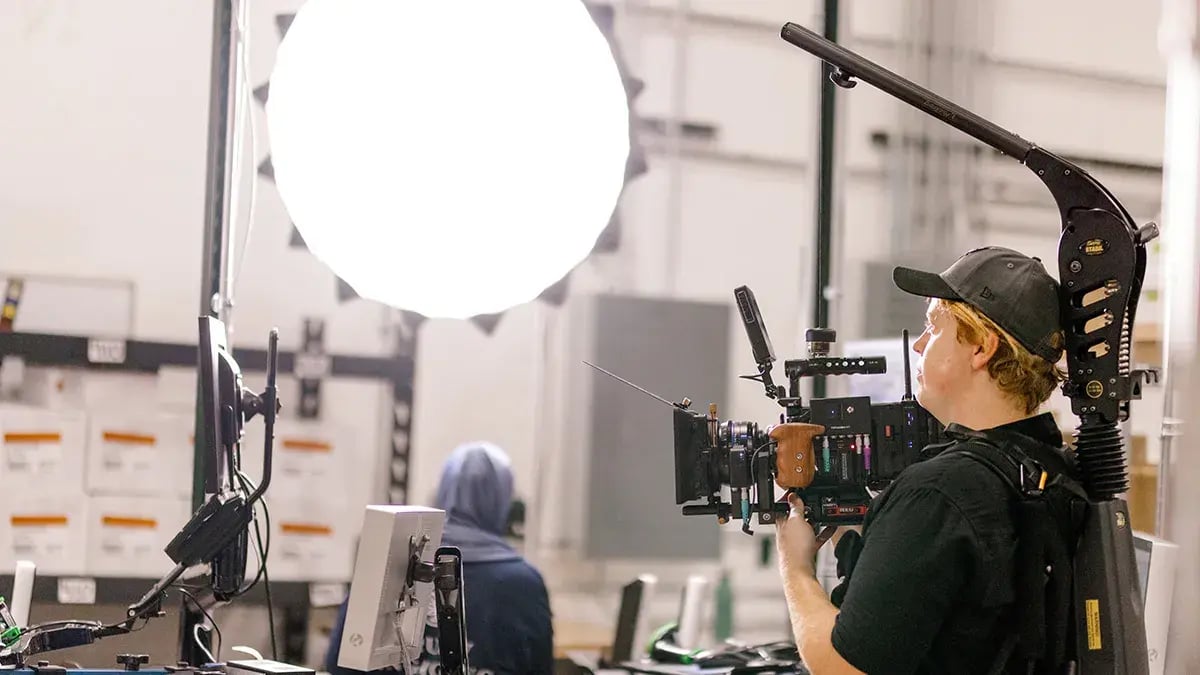 during a corporate video production, a cameraman films an employee working at Truly Engaging