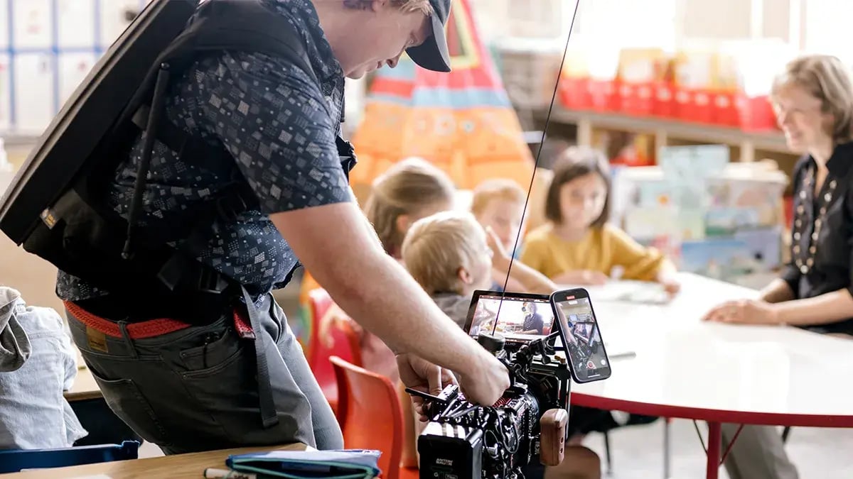 a camera operator from Charter & Co films with a camera during a non-profit video production for Wheaton Christian Grammar School