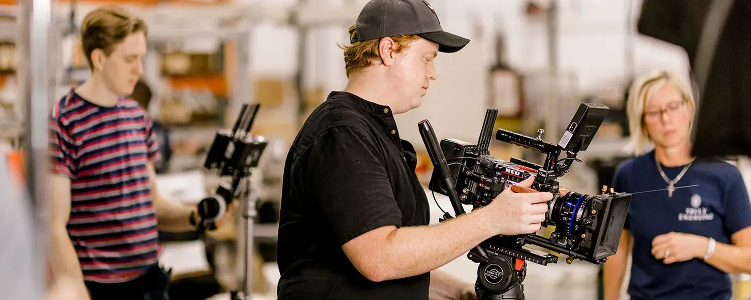 A man operates a camera rig on a video production set.